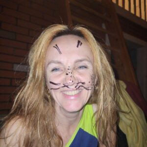 A woman in glasses and a coat stands confidently